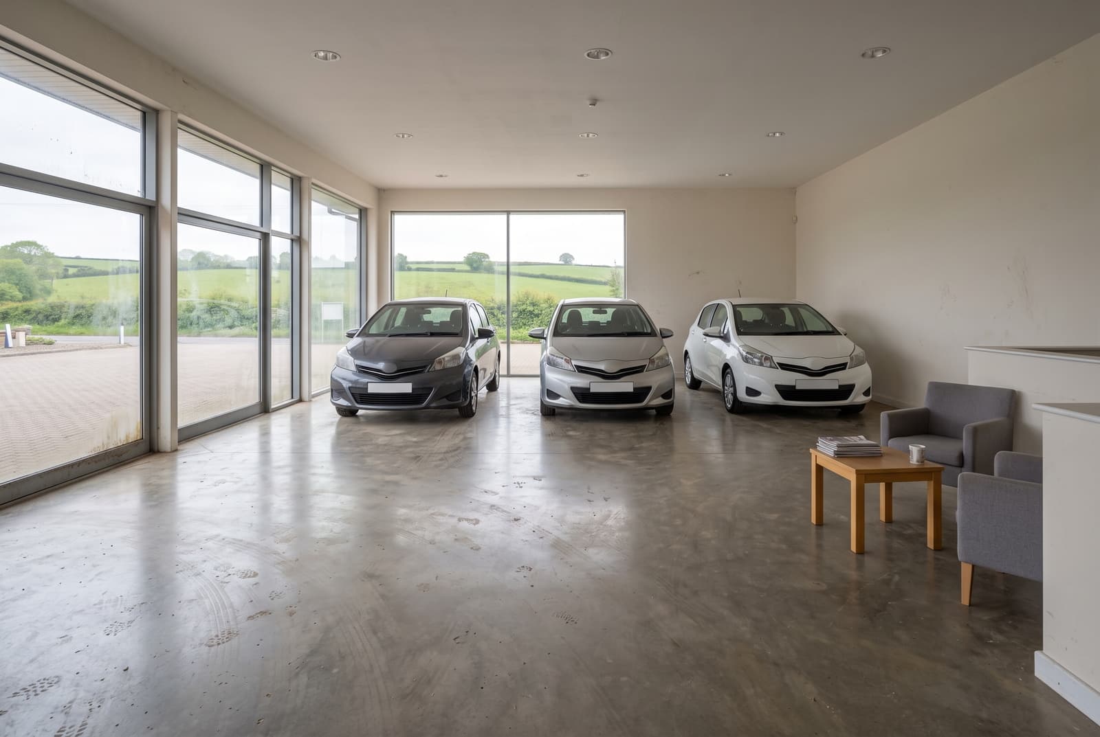 Devon car showroom before cleaning, with a hazy dulled floor, tyre scuffs and smudged glass frontage