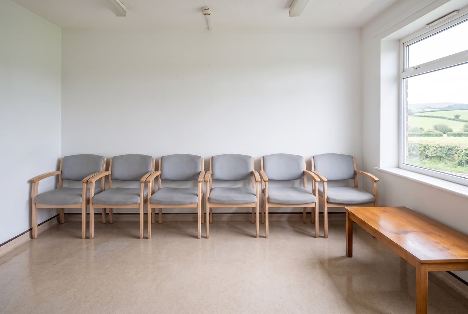 Same Devon surgery waiting room after medical cleaning, buffed vinyl floor, spotless chairs and bright clean walls