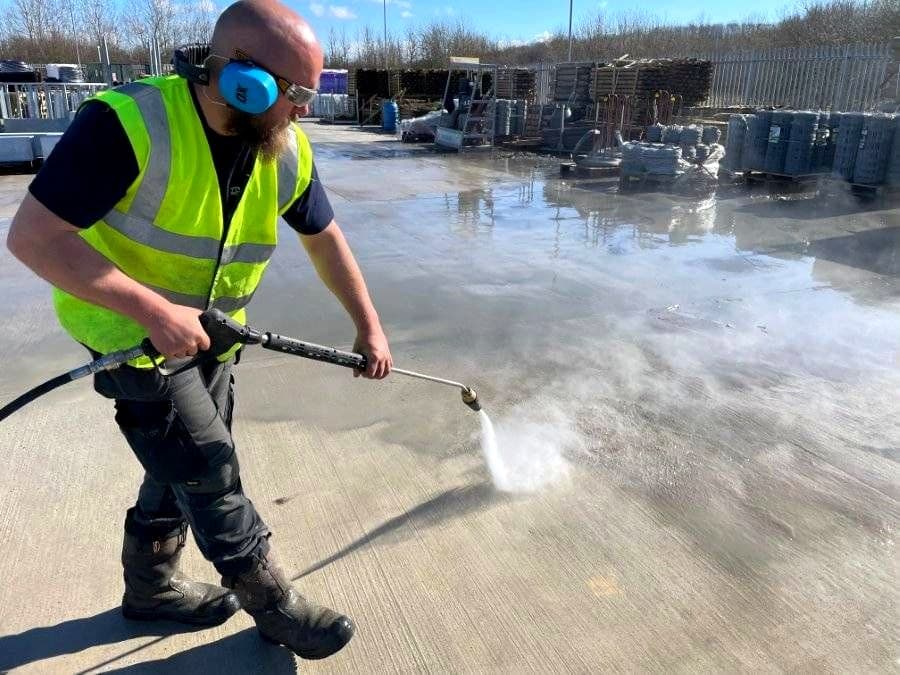 Moor Cleaning operative pressure washing a commercial yard in Devon